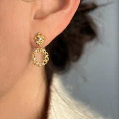 lacy, textured 14k and diamond earrings made of two parts: a small, circular top part and a wreath-like bottom part; shown on ear