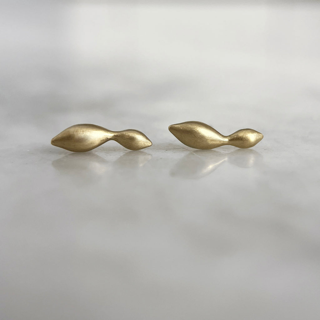 two yellow gold curvy studs that look like connected seaweed bulbs
