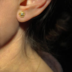 Lacy, textured, star-like stud earring with center stone, shown with white diamond and on ear; head in profile