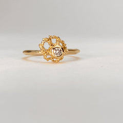 Textured, fan-shaped ring with negative space and off-center bezel with stone; shown with diamond