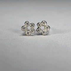 a stud made of 5 small bud-like balls in an open circle, each one set with a diamond; shown in silver