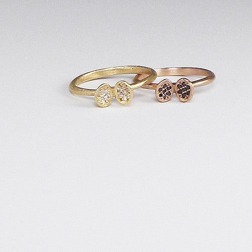 Ring with small clamshell-like sculpture on top; each side of shell has 7 pavé diamonds; shown in yellow gold with white diamonds and rose gold with black diamonds