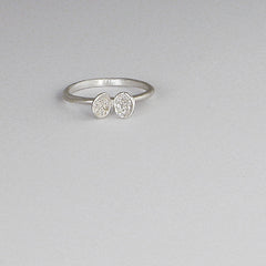Ring with small clamshell-like sculpture on top; each side of shell has 7 pavé diamonds; shown in silver with white diamonds 