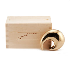 Snail-like bronze bottle opener shown next to wood box packaging