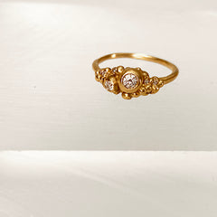 Cluster of tiny gold buds with tiny diamonds, and 2 larger pods with larger diamonds; view more from top