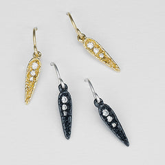 Textured, concave, spear-like shape, rounded at top and tapered at bottom, with short, vertical row of 3 consecutively smaller diamonds starting at top and ending 1/2 way down center; shown in blackened silver and yellow gold