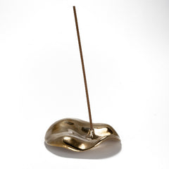 Low profile incense holder in cast bronze with flared, ruffled, skirt-like design