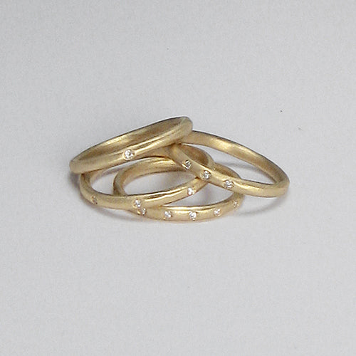 Very slim, gently faceted band, shown with various numbers of diamonds; shown in yellow gold